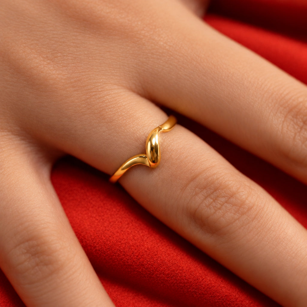 Gold ring on a finger against an orange background