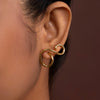 Gold ear cuff worn by a person with a brown background