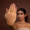 Woman wearing gold rings on a brown background