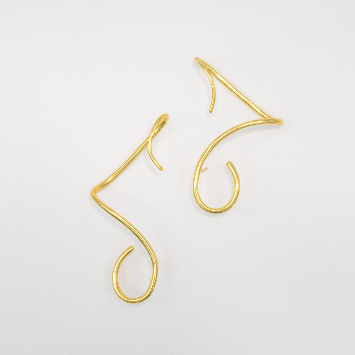 Gold earcuffs on a light gray background