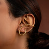 Gold ear cuff worn by a person with a blurred background