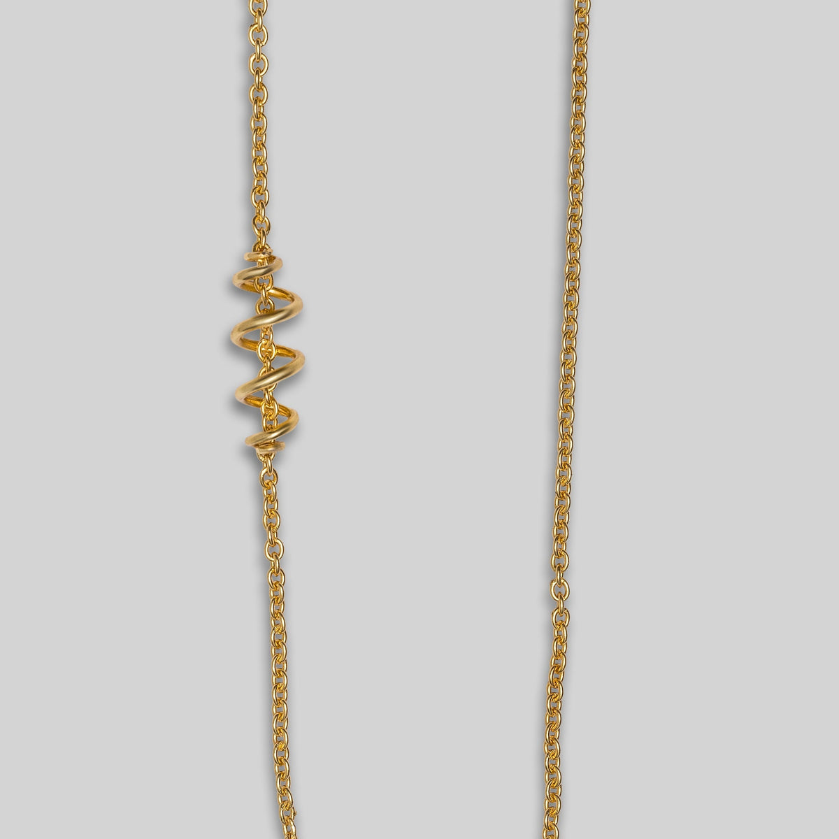 Gold necklace on a light gray background