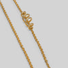 Gold chain necklace on a light gray background