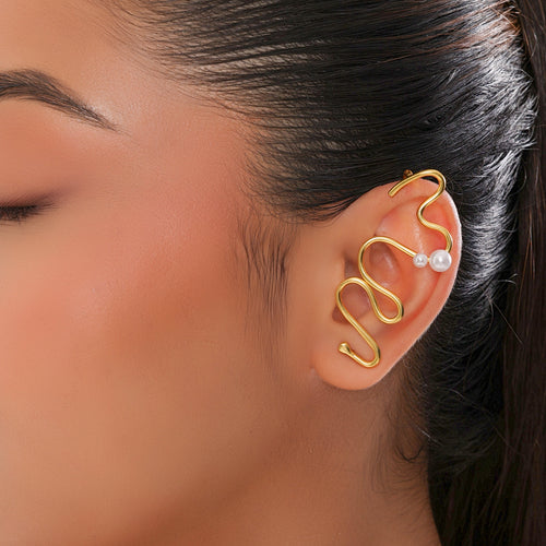 Gold ear cuff with pearl accent worn by a model
