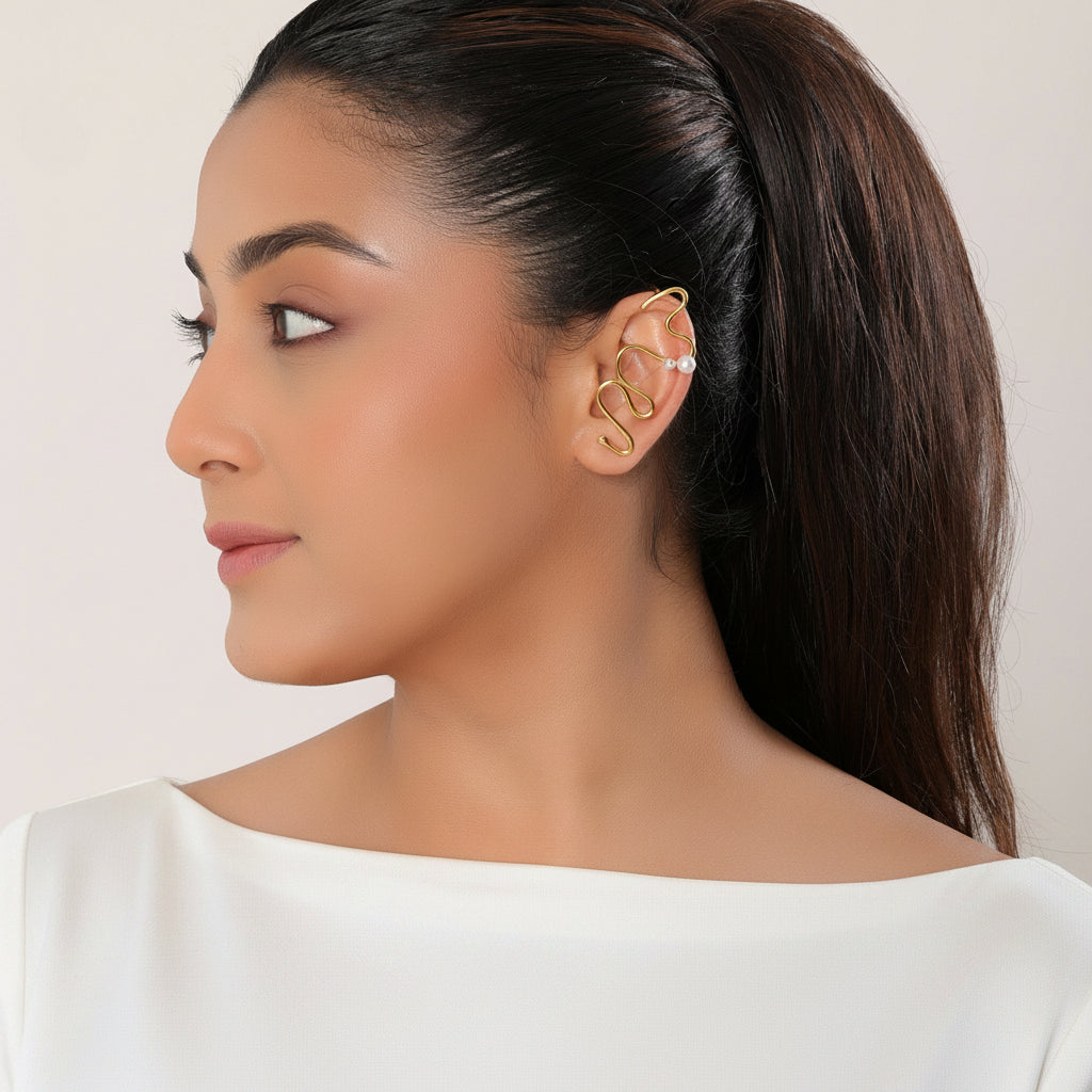 Woman wearing gold earrings with a plain background
