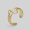 Gold bracelet on a light gray background