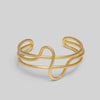 Gold wire bracelet on a light gray background