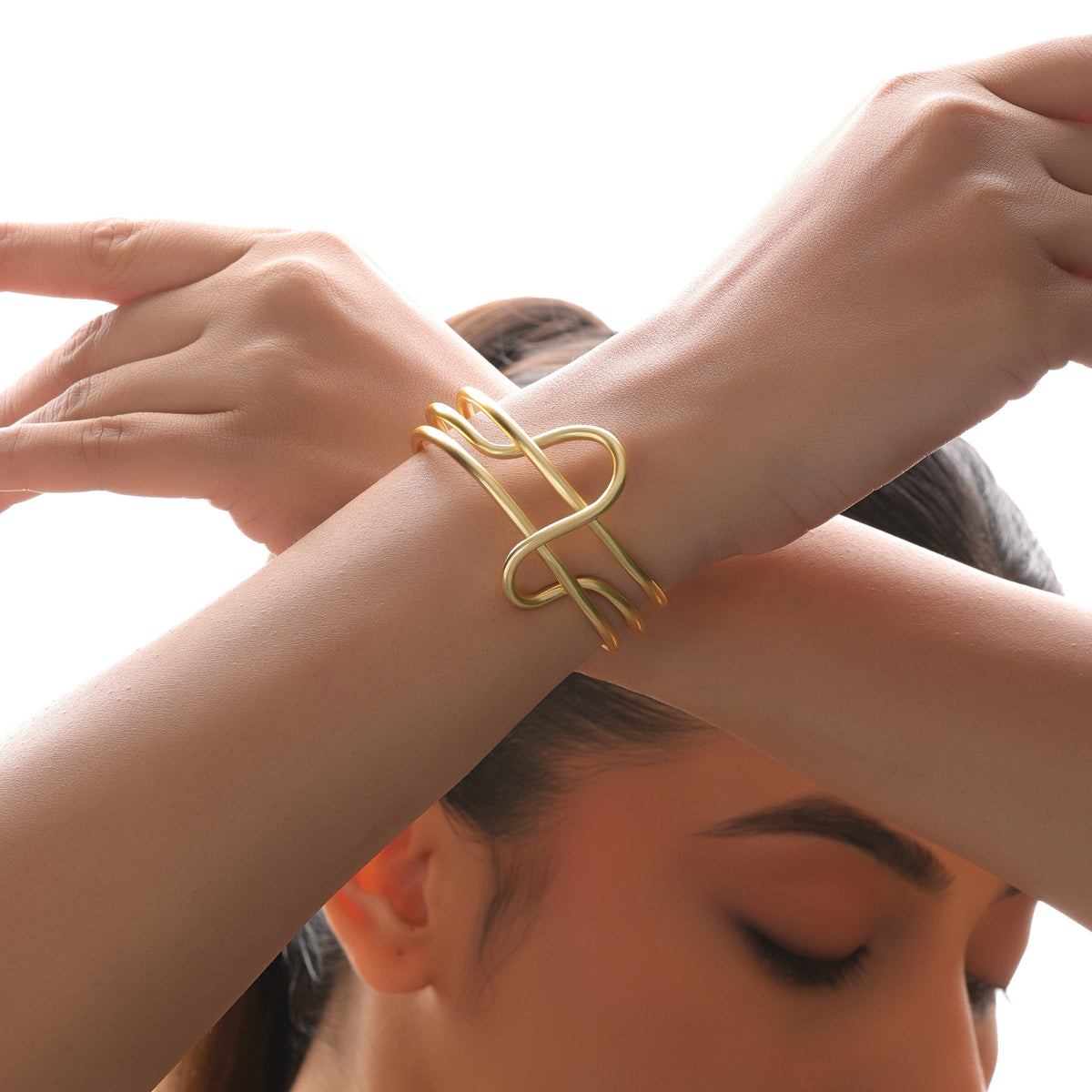 Woman wearing a gold bracelet on a white background