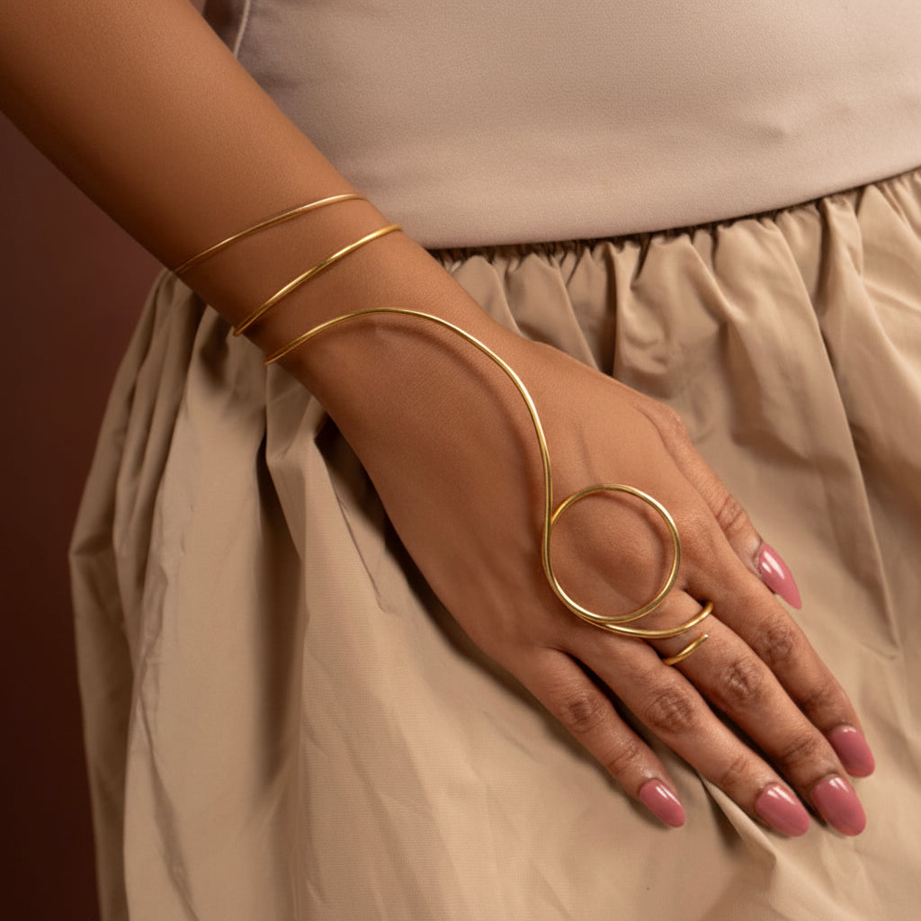 Gold arm cuff on a hand with a beige outfit