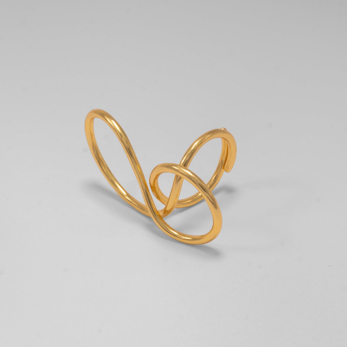 Gold open ring on a light gray background