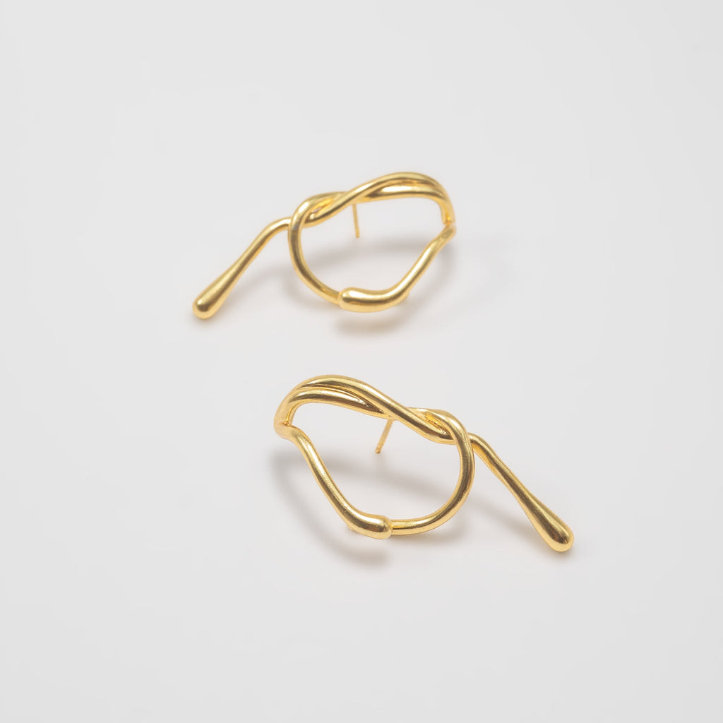 Pair of gold earrings on a light gray background