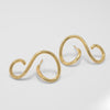 Pair of gold spiral earrings on a light gray background