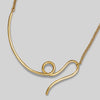Gold necklace with a unique design on a light gray background