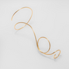 Gold wire bracelet on a light gray background