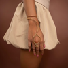 Person wearing a gold arm band on a brown background