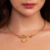 Gold necklace with a unique pendant design worn by a person