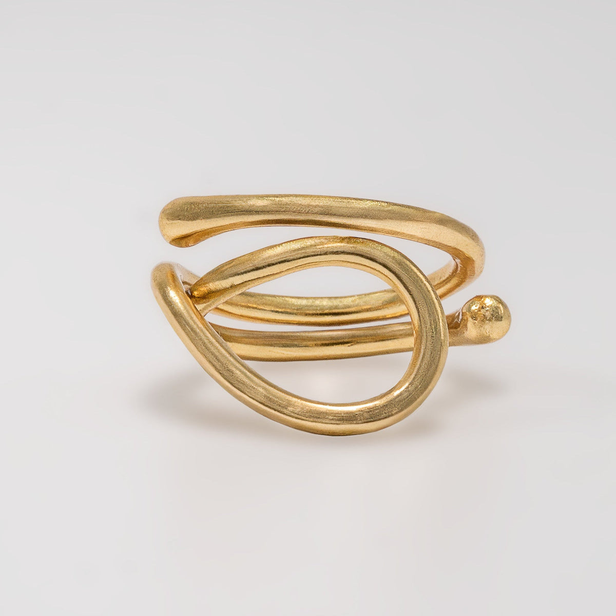 Gold ring with a modern design on a light gray background