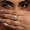 Close-up of a hand with a gold ring, covering part of the face.