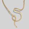 Gold necklace with a unique pendant on a light gray background