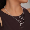 Silver necklace worn by a women against a neutral background
