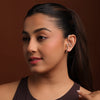 Woman wearing a silver earcuff against a brown background