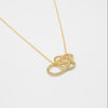 Gold necklace with a Celtic knot pendant on a white background