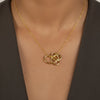 Gold necklace with a intricate pendant on a person's neck