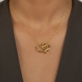 Gold necklace with a intricate pendant on a person's neck