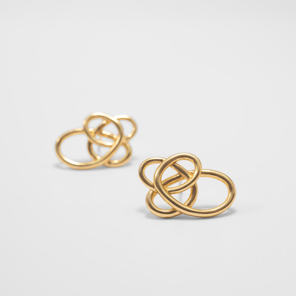Pair of gold earrings on a light gray background