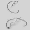Pair of silver earcuffs on a light gray background