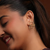 Woman wearing a gold earring with a blurred background