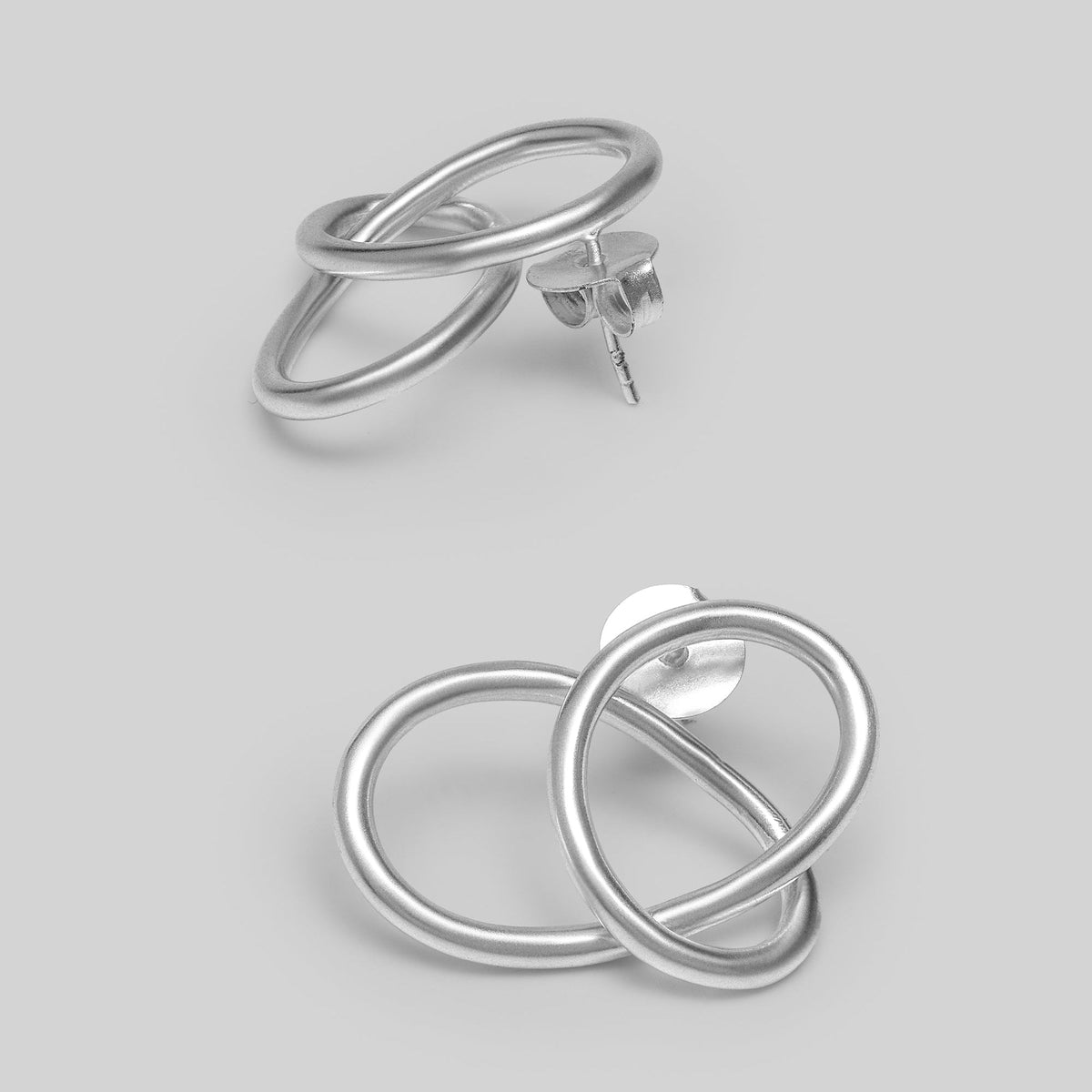 Pair of silver earrings on a light gray background