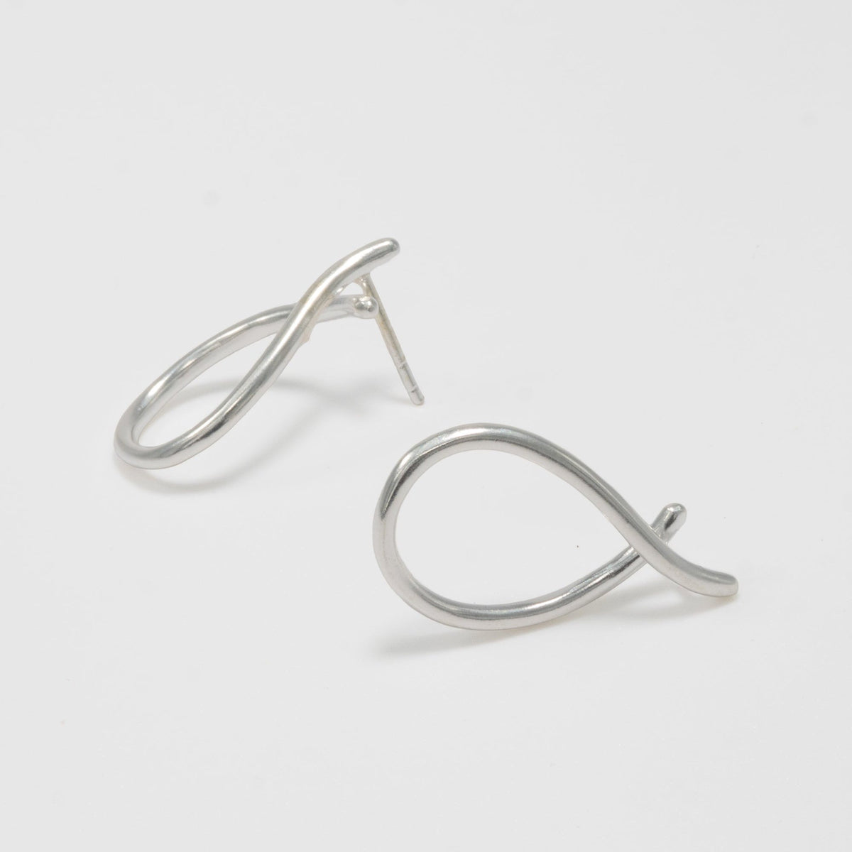 Pair of silver earrings on a light gray background
