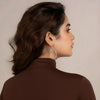Woman wearing silver earrings with a neutral background