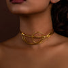 Gold necklace worn by a person with a blurred background