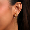 Gold earrings worn by a person with dark hair.