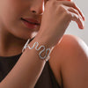 Woman wearing a silver bracelet with a neutral background