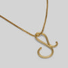 Gold necklace with a unique pendant on a light gray background