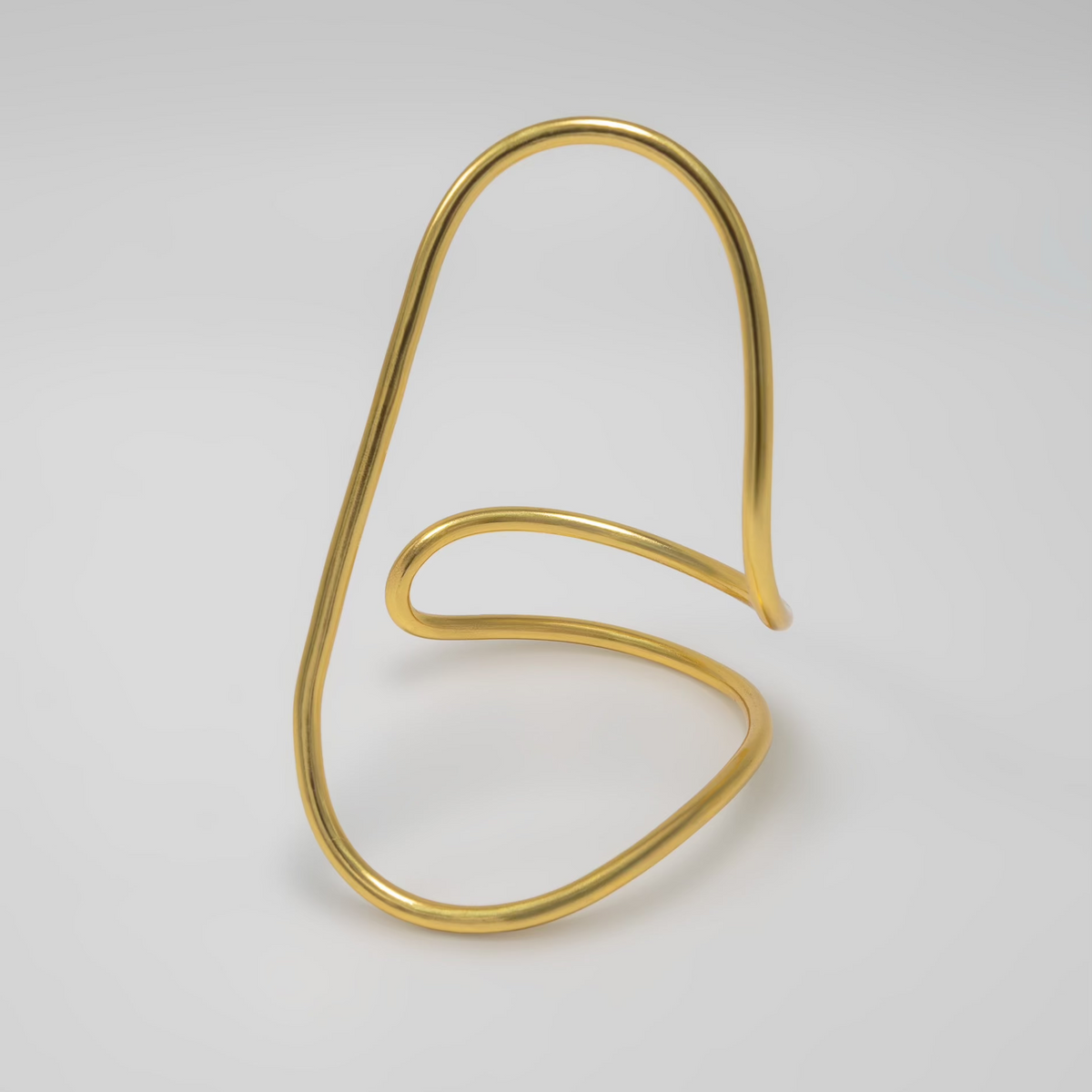 Gold wire bracelet on a light gray background