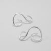 Pair of silver earrings on a light gray background