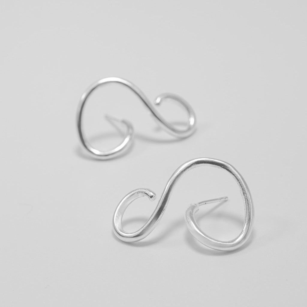 Pair of silver earrings on a light gray background