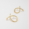 Pair of gold earrings on a light gray background